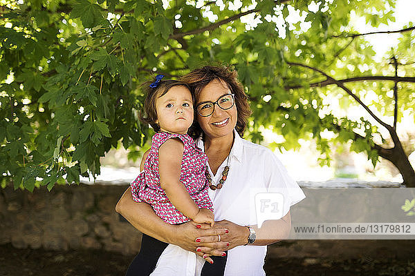 Portrait of smiling mature woman with baby girl