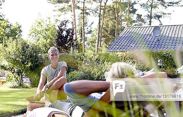 Frau im Gespräch mit ihrem Partner im Garten