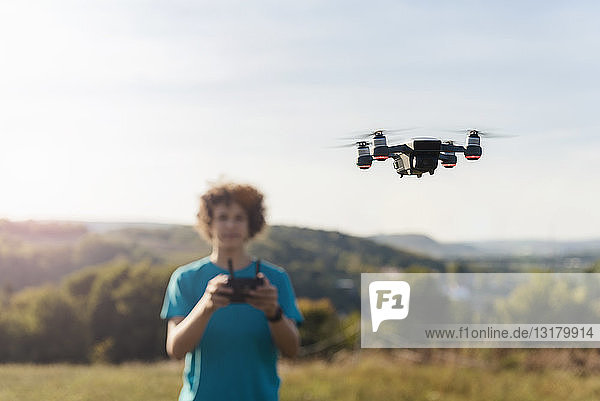 Boy navigating a flying drone outdoors