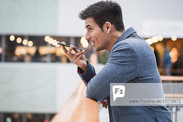 Businessman in lobby of a modern building  using smartphone