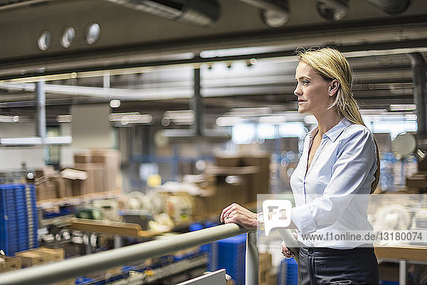 Businesswoman in factory overlooking storehouse