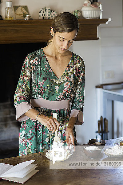 Young woman preparing cake dough