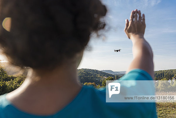 Boy navigating a flying drone outdoors