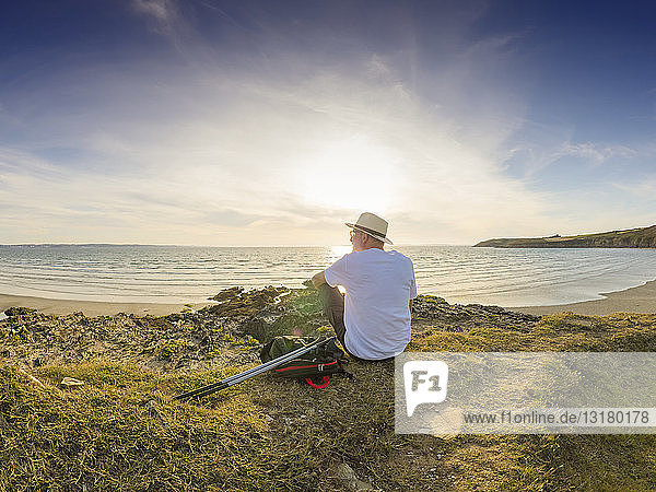 Frankreich  Bretagne  Älterer Mann macht eine Pause am Strand  sitzt auf einer Düne
