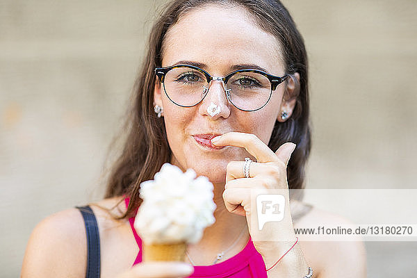 Porträt einer lächelnden jungen Frau beim Eisessen