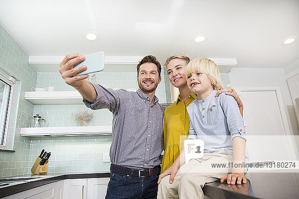 Vater nimmt Selfie mit seiner Familie in der Küche