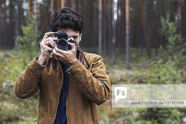 Finland  Lapland  man taking picture in rural landscape