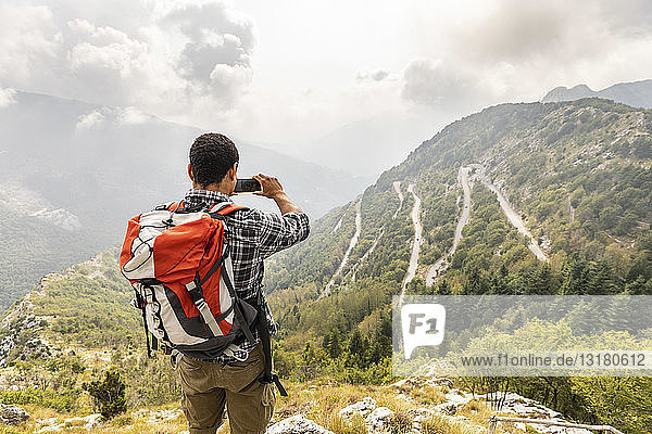 Italy  Massa  man hiking and taking a picture of the view in the Alpi Apuane