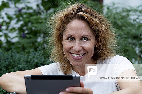 Porträt einer lächelnden Frau mit digitalem Tablett