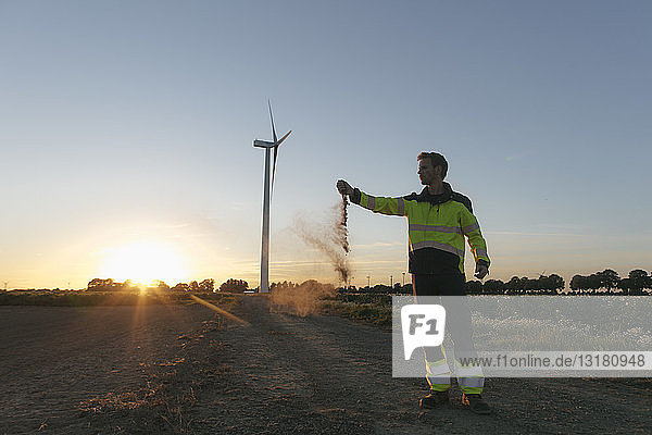 Ingenieur an einer Windkraftanlage bei Sonnenuntergang Streuboden