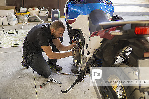 Mechanic working on motorcycle in workshop