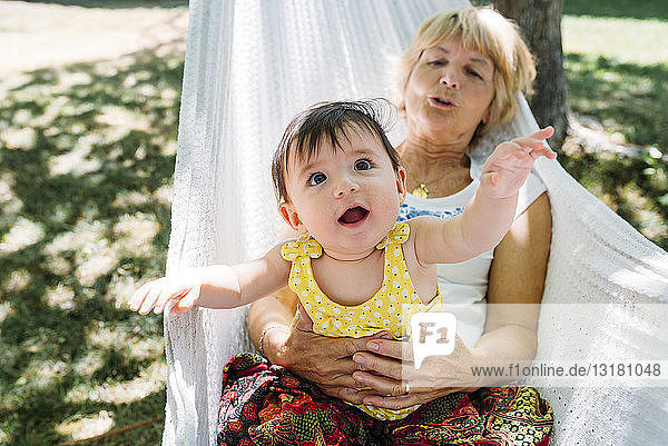 Spanien  Oma und Baby entspannen sich im Sommer in einer Hängematte im Garten