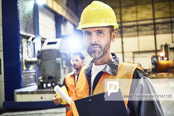 Porträt eines selbstbewussten Mannes mit Arbeitsschutzkleidung in der Fabrik