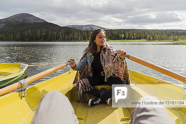 Finnland  Lappland  Frau mit einer Decke in einem Ruderboot auf einem See