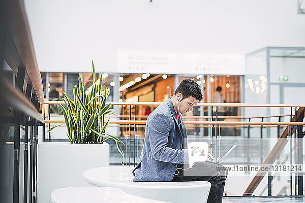 Businessman in lobby of a modern building  using smartphone