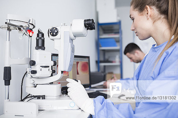 Labortechniker  der im Labor mit dem Mikroskop arbeitet
