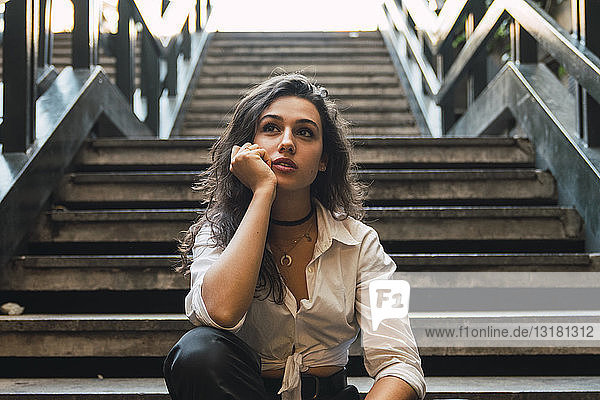 Portrait of young woman sitting on stairs