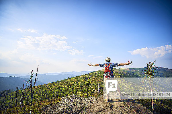 Rear view of hiker in mountains enjoying the view