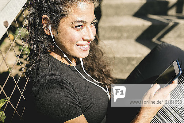 Sporty young woman having a break listening to music