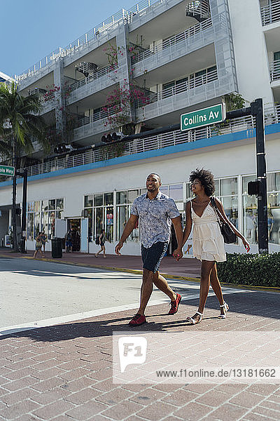 USA  Florida  Miami Beach  happy young couple crossing the street