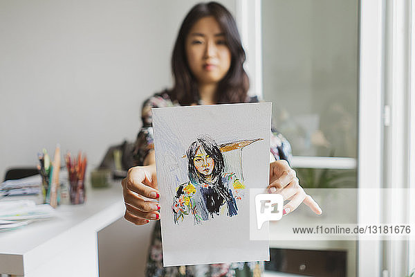 Illustrator showing drawing with self-portrait