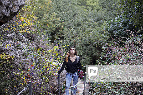 Spain  Alquezar  young woman on a hiking trip walking on boardwalk