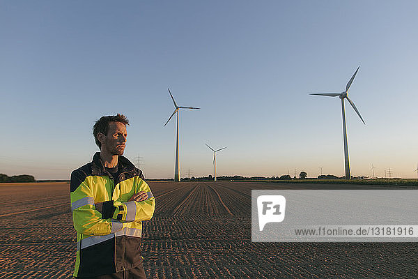 Ingenieur  der auf einem Feld eines Windparks steht
