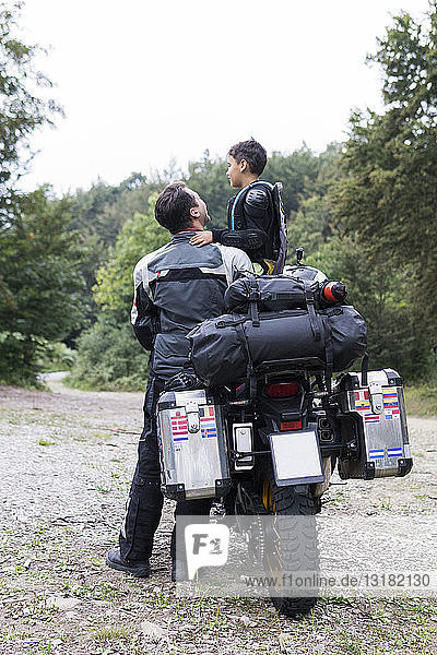 Vater und Sohn machen eine Pause während einer Motorradtour