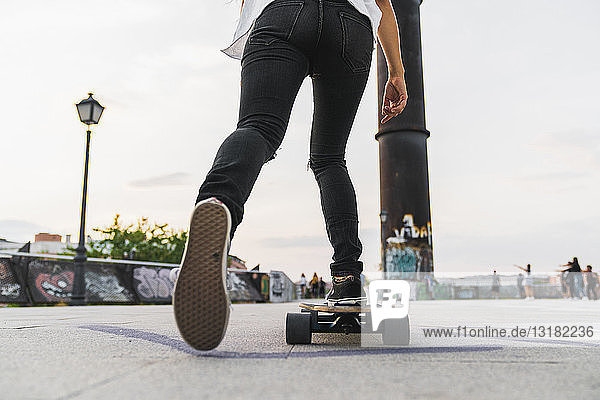 Nahaufnahme einer jungen Frau beim Skateboardfahren in der Stadt