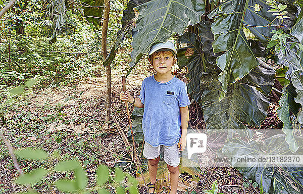 Brazil  Bonito  boy standing in jungle under large leaf