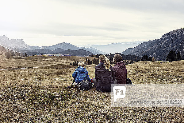 Italien  Südtirol  Geissler-Gruppe  Familienwandern  auf der Wiese sitzen
