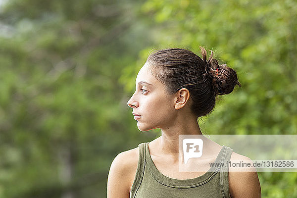 Porträt einer jungen Frau im Freien mit Blick zur Seite