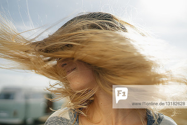 Blonde junge Frau im Wohnmobil schüttelt ihr Haar