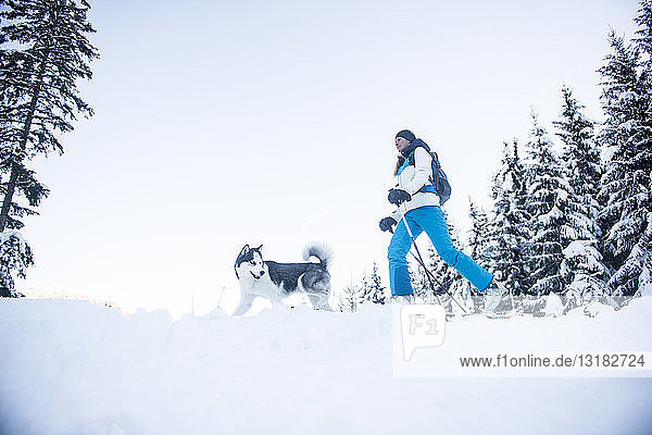 Österreich  Altenmarkt-Zauchensee  junge Frau mit Hund im Winterwald