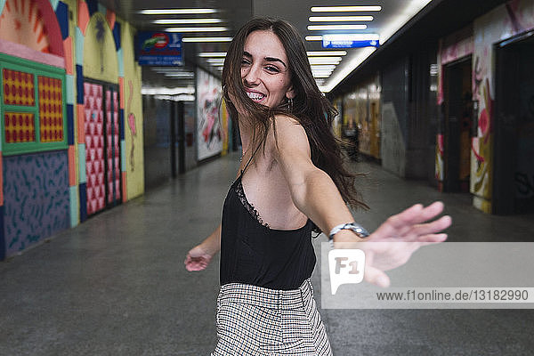Porträt einer lachenden jungen Frau in einem Korridor