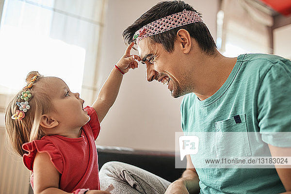 Vater und kleines Mädchen amüsieren sich gemeinsam zu Hause