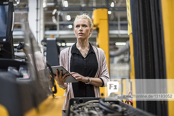 Woman holding tablet in factory shop floor