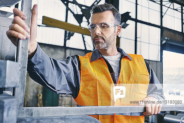 Mann trägt Arbeitsschutzkleidung bei der Arbeit in der Fabrik