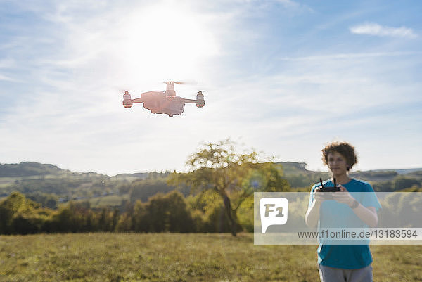 Boy navigating a flying drone outdoors