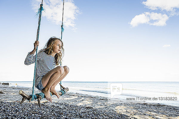 Girl on a swing at the beach