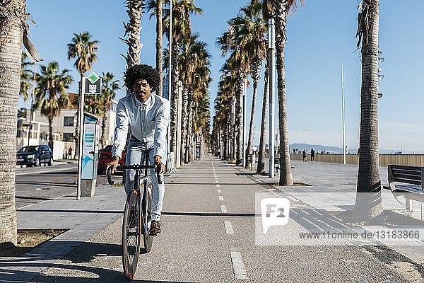 Mittelgroßer erwachsener Mann auf dem Fahrrad in der Stadt  in Strandnähe