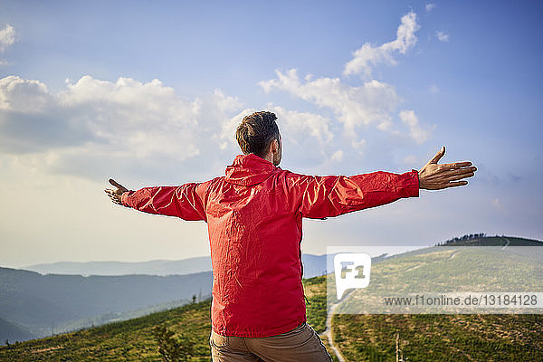 Rear view of hiker in mountains enjoying the view