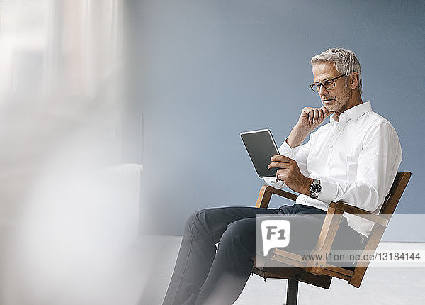 Manager sitzt im Büro und verwendet ein digitales Tablett