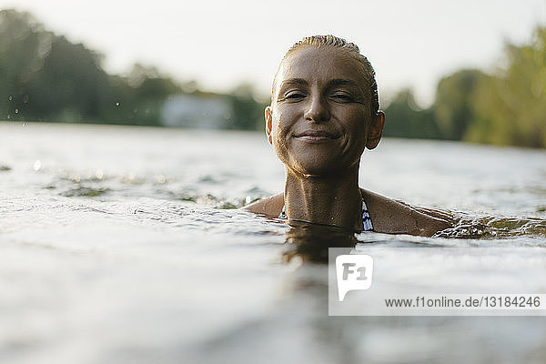 Portrait of smiling woman swimming in a lake