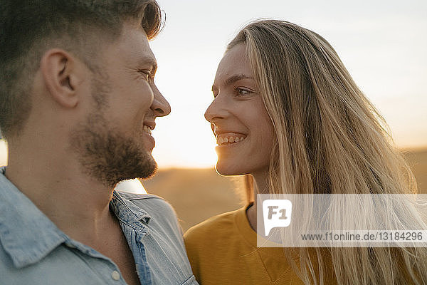 Glückliches liebevolles junges Ehepaar in ländlicher Landschaft