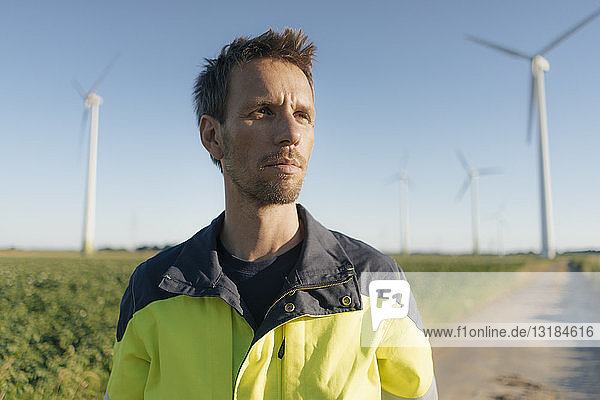 Porträt eines Ingenieurs auf dem Feldweg in einem Windpark