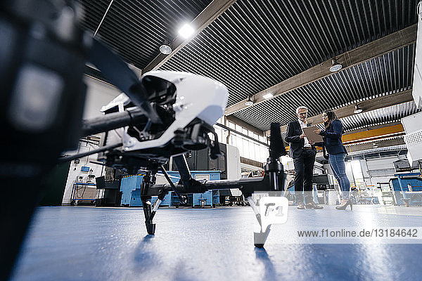 Geschäftsmann und Mitarbeiter diskutieren über die Produktion von Drohnen
