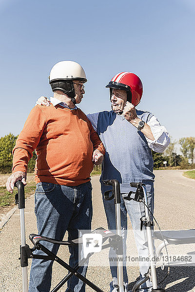 Zwei alte Freunde mit Schutzhelmen  die sich auf ein Laufrad-Rennen vorbereiten