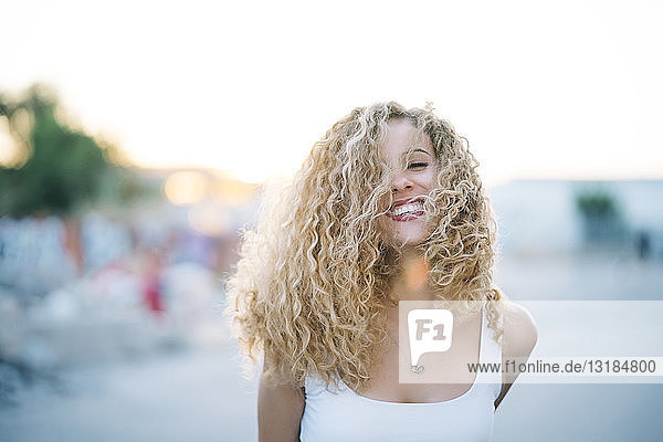 Portrait of happy young woman with blond ringlets