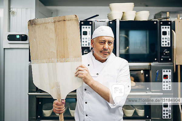 Porträt eines Bäckers mit Schale in einer Bäckerei